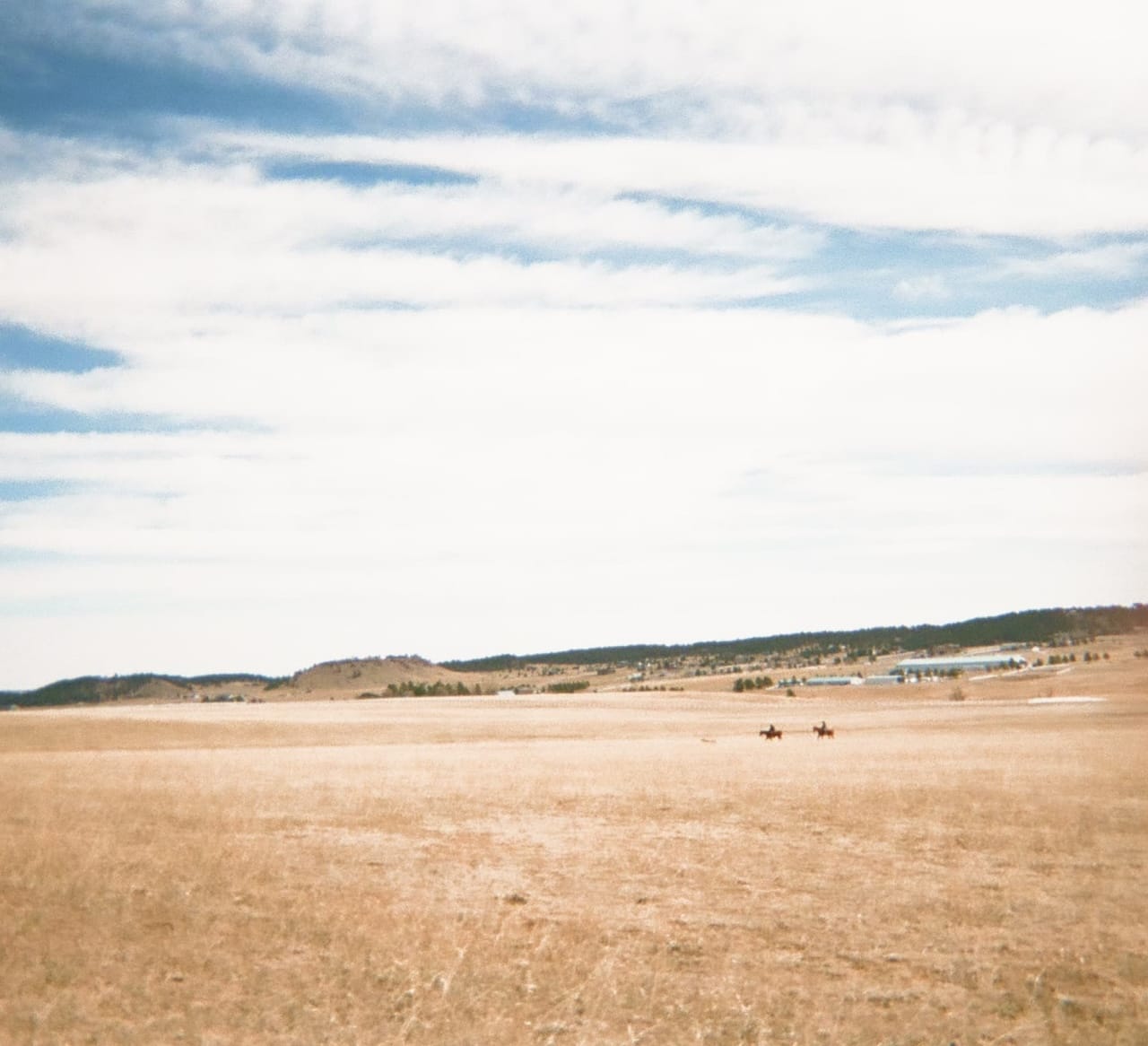 A peaceful hay field with a blue sky.